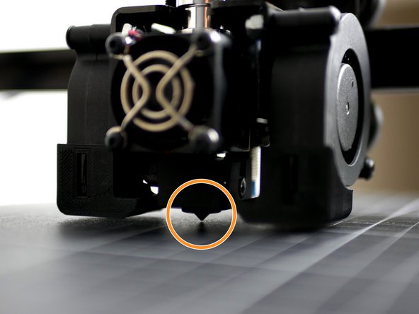 Lower the gantry so that the nozzle comes close to the print surface. Once close enough the red light on the probe should come on.  At this point the nozzle should only be a fraction of a milimeter above the print surface. The bottom of the probe should always remain above the tip of the nozzle.