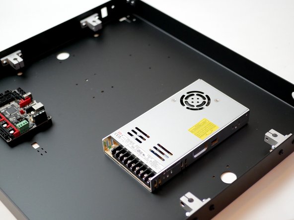 An easy way to line up the holes is to place the PSU under the base and look through the holes from the top until they line up, and you can secure one of the bolts. The rest should then easily follow.