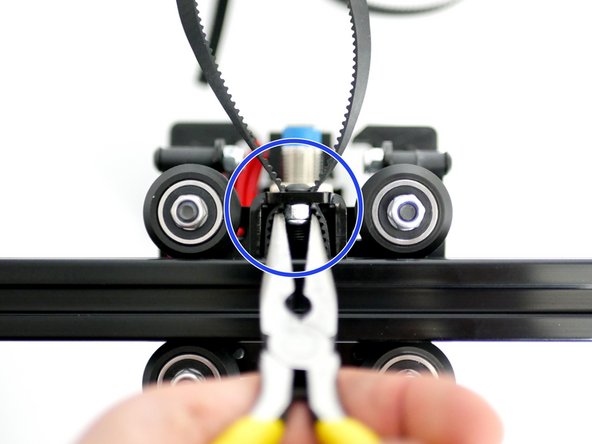 The teeth of the belt should catch on the bolts head holding the tension temporarily.