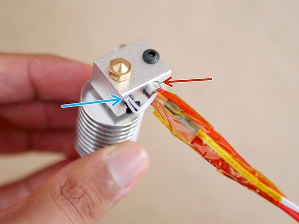 Take the heater cartridge and thermistor cable assembly and push the heater cartridge into the large hole...