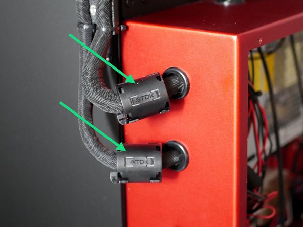Clip the two large ferrite sleeves to the cable looms entering the rear of the enclosure.