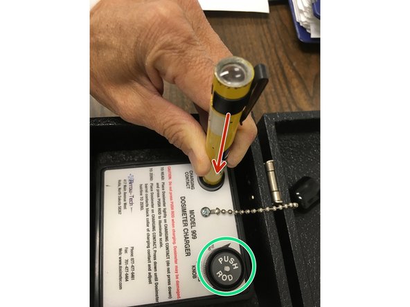 Set dosimeter on discharger and apply a downward force.