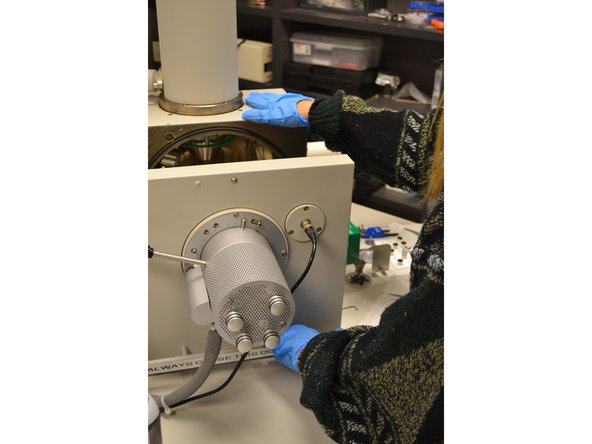 Watch the video screen and slowly open the SEM door by its handle using the proper two-hand technique.