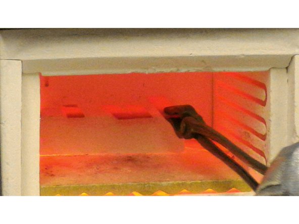 Operator B : While wearing the proper safety gear, use the tongs to put the workpiece in the center of the oven on the white alumina brick.