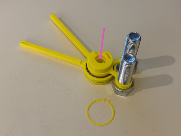 Screw the large bolts into the mouse ears such that the bolt heads are on the tall side of the mouse ears.