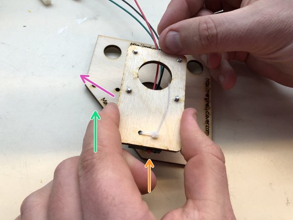 Mount the switch plate on top of the screws.  The cables should come out along thie purple arrow, NOT go between the screws as this picture shows.