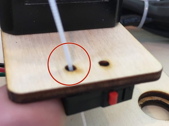 Through one of the two holes put a zip tie through one of the holes on the limit switch