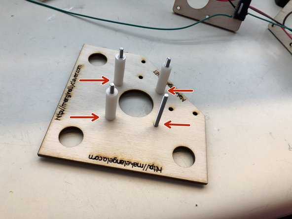 insert four M3x35 screws into the holes, flip the board over, and then put one 25mm spacer on each screw.  This picture shows only three spacers on four screws.