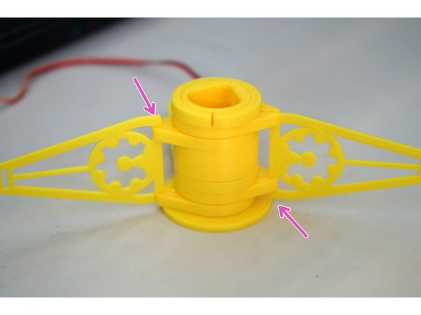 Put the servo mounting plate onto the tube, servo side down, on top of the pair of clips.