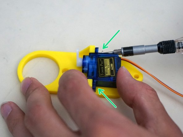 Use a Phillips (x) screwdriver to attach the servo horn onto the servo output gear with the two servo horn screws.