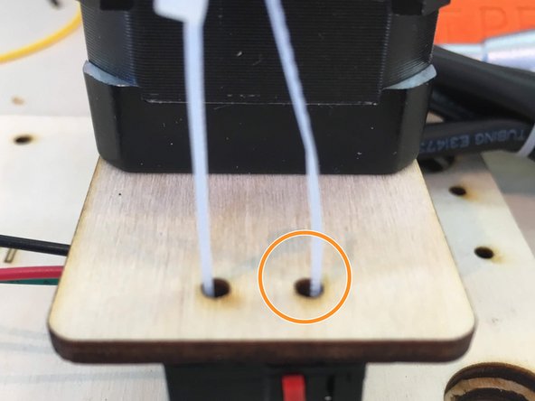 Bend the end of the zip tie around and place back up through the second hole