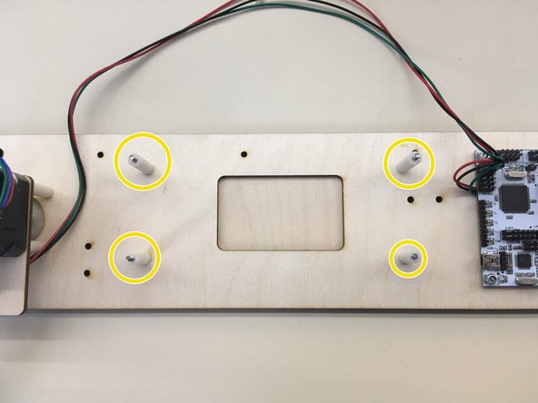 Slide on four 25 mm spacers onto screws