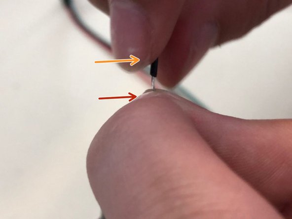 Pinch the exposed wire gently between thumb and finger.