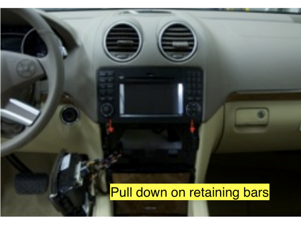 Slide the bars downward until they stop. These are the radio retaining bars.