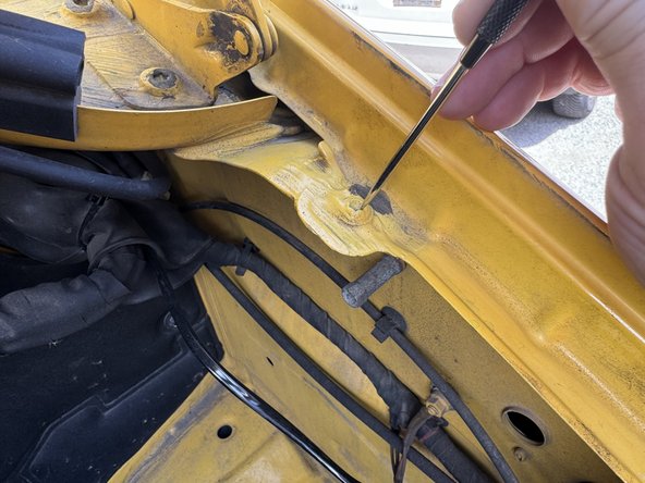 Clean screw on drivers’ side of hood opening with pick tool or small screwdriver to remove body sealant if present.