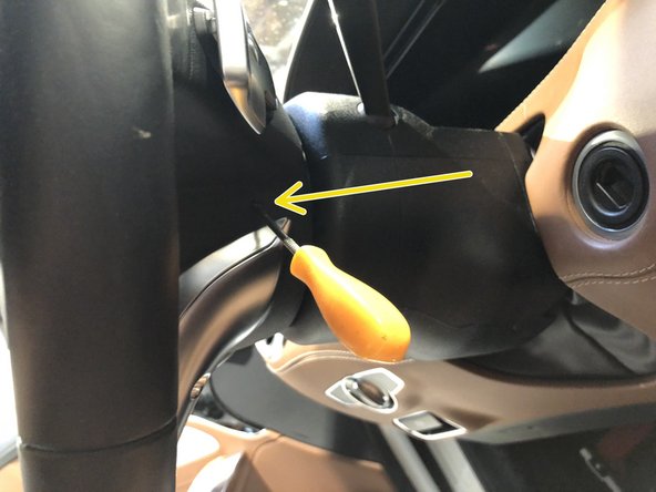 Release clips on both sides of steering column (insert tool to release on each side)