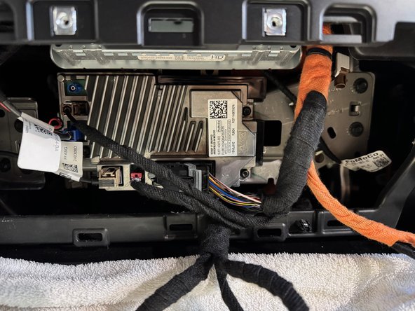 Unbolt radio/climate controls and remove panel
