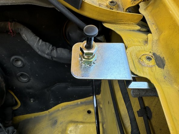 Slide pin switch bracket between the two pieces of metal on the fender mount