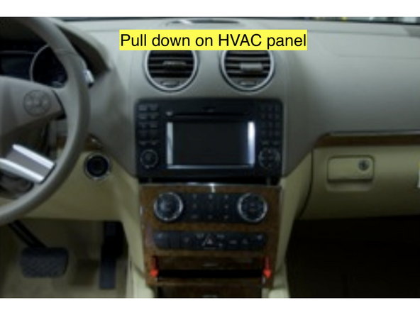 Pull down on the panel to release the upper clips