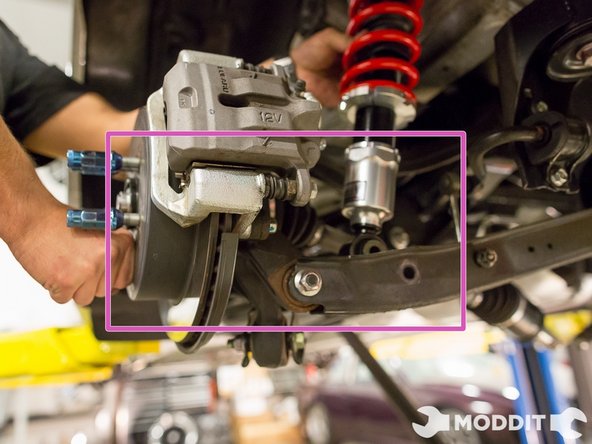 While the strut is hanging down,  we pushed down on the hub to slither the strut into the control arm.  (Same method as removal)