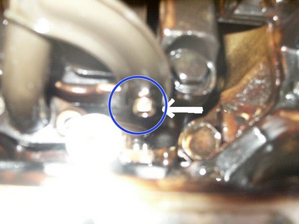 Using an 11mm wrench, remove the bolt on the side of the strainer bracket.