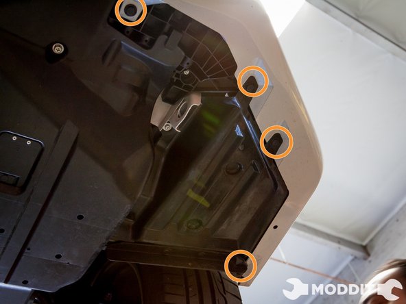 Then under the car, there are a series of clips that connect the bumper to the under tray. Pop those out as well with the small pick or screw driver.