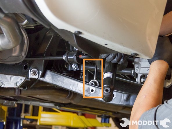 Next, we removed the end link from the control arm itself with a 14 mm socket and wrench. We did this on both sides so that one side would not have more tension than the other. We found out that doing this reduced the amount of effort needed to remove the lower portion of the stock strut &amp; spring from the lower control arm.