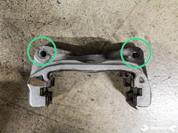 Using a 17 mm wrench, remove the two bolts securing the caliper to the knuckle.