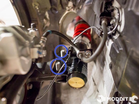 Once you have it hanging, go ahead and align the knuckle to the shock assembly. Then insert the bolts in there to keep it all together. Like the rear, you may have to use a mallet to get them in there completely.