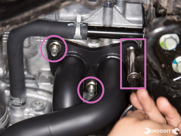 With header slipped through the studs and the gasket sandwiched between, go ahead and start threading the nuts on. These nuts can support the weight of the header so you can let go once the nuts are on the studs.