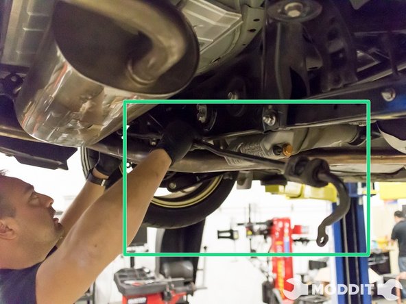 Carefully slide it towards the passenger side of the car and be careful not to damage things on the way out.