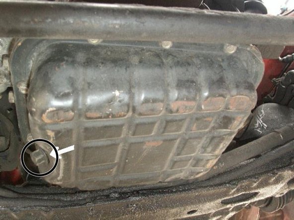 Position an oil drain pan underneath the  vehicle to catch all the oil.