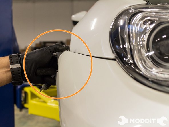 After you remove this clip the sides of the front bumper should easily come off.