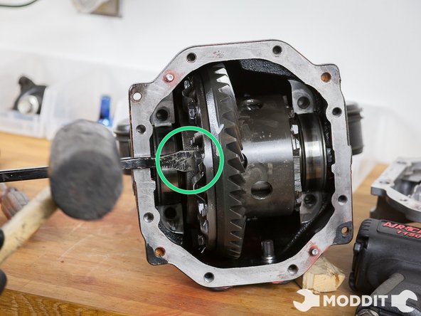 Using either a strong flat-head screwdriver or crow bar find strategic points to tap out the diff'. What you could do is screw back some on some of the bolts used to secure the LSD Ring and use them as leverage. Simply tap and use force, without overdoing it.