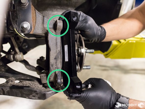 Utilizing the factory caliper bracket bolts, install the upgraded aluminum caliper bracket