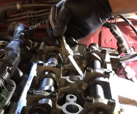 You will need a feeler gauge to measure each gap between the short part of the came lob to the cam bucket/cam follower. The measurement should be approximately .010” to .012” cold.