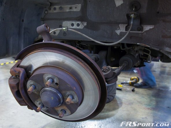 Once these are loosened you'll notice the coilover dropping, grab it with your hand or use a friend to help secure it so it doesn't fall.