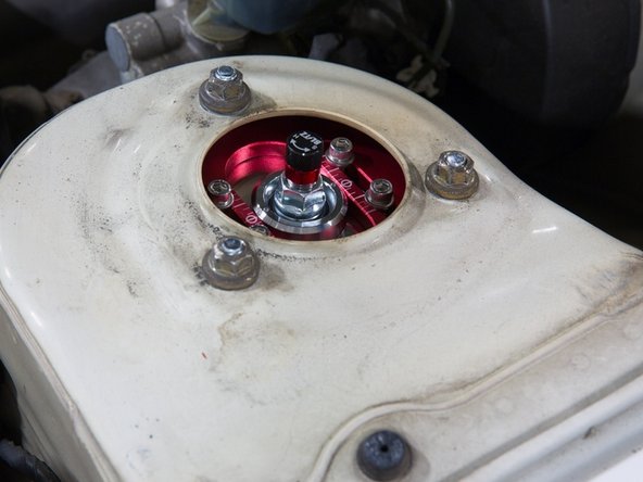 Loosen the top 3 nuts on the strut tower.