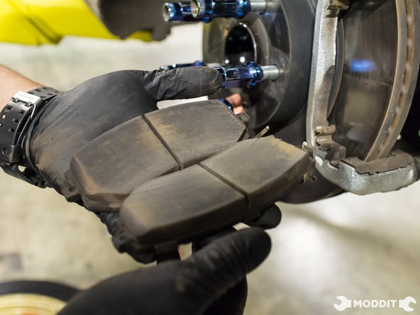 Once the caliper has been secured, the brake pads can be easily removed and set aside.