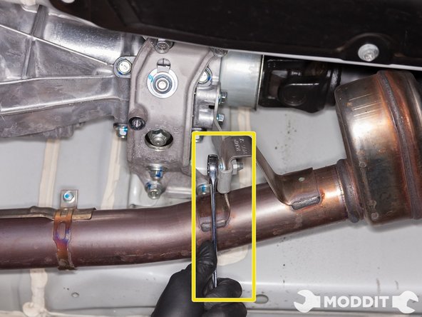 Utilizing a 14mm wrench, remove the bolt supporting the front pipe to the transmission mounting bracket.