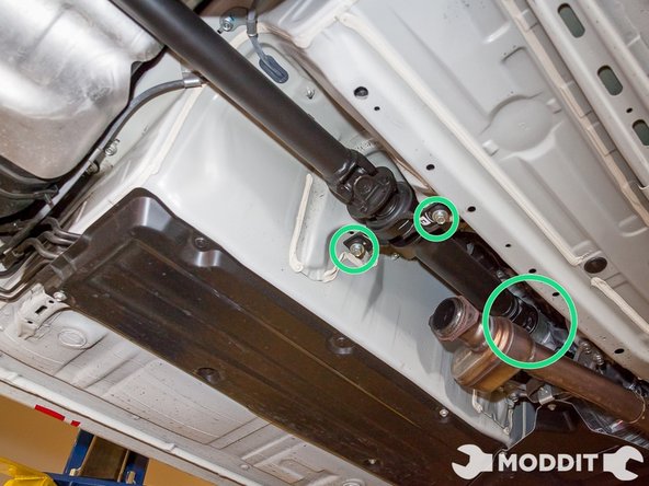 Loosen two bolts holding up the center of the driveshaft. We would recommend not removing them.