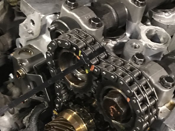 Some engines have an upper chain guide held on my 2 bolts. This may not we removed. Our specific build did not have them.