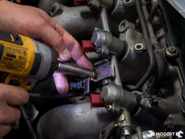 When removing the bolts, be careful not to drop the spacers that are under the fuel rail tabs.