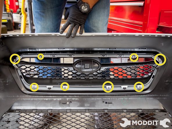 After the front bumper removal, locate the 8 Phillips head screws on the back of the grille.