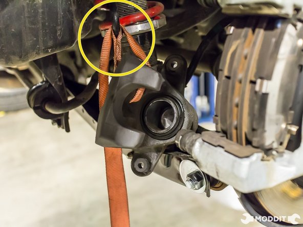 After removing the caliper, securely support it so it does not add stress to the brake line.