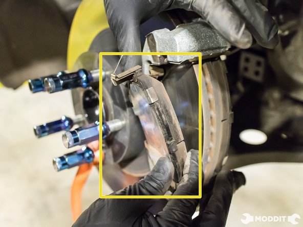 Once the caliper has been secured, the brake pads can be easily removed and set aside.