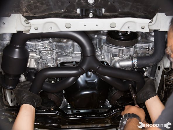 With your partner, hold the gasket to the flange of the header while lifting it up to mate with the engine. Once lined up and the studs are through the gasket and flange, you're ready to thread on the nuts.