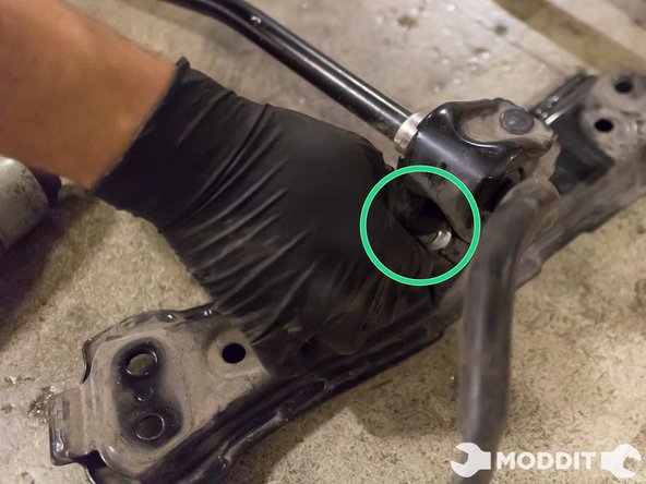 Once out, you can place the sway bar assembly on the ground. Using a 14 mm socket, remove the top-side bolt found in the pair of brackets securing the u-shaped bracket to the sway bar.