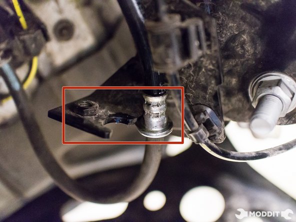 Utilizing a 12 mm wrench, remove the bolts securing the brake line to the suspension.