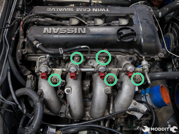 After the removal of the hoses, start removing the bolts that hold the rail to the intake manifold.